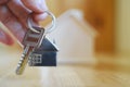 Hand holding giving key chain with house shaped pendant Royalty Free Stock Photo