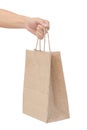 Hand holding and giving paper bag isolated over white background Royalty Free Stock Photo