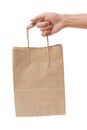 Hand holding and giving paper bag isolated over white background Royalty Free Stock Photo