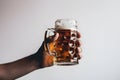 Hand holding a glass of beer on a white background. Neural network AI generated Royalty Free Stock Photo