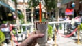 Hand holding glass of chocolate milkshake on blurred background