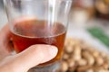 Hand holding a glass of fresh beer with peanuts on a table with a blurred background. Royalty Free Stock Photo