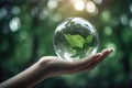 hand holding glass globe ball with tree growing and green nature blur background AI generated