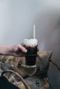 Hand holding a glass of iced black coffee with milk foam on top vintage background Royalty Free Stock Photo