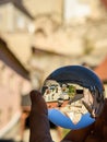 Hand holding glass sphere in front of church