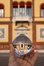 Hand holding glass sphere in front of old house Royalty Free Stock Photo