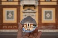 Hand holding glass sphere in front of old house Royalty Free Stock Photo