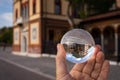 Hand holding glass sphere in front of old house Royalty Free Stock Photo
