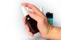 Hand Holding Glass Spray Bottle with bottles in background Royalty Free Stock Photo