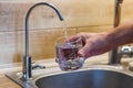 Hand holding a glass of water. a man  pouring water from filter tap. clean water and healthy life concept Royalty Free Stock Photo