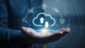 Hand holding a glowing cloud icon with data and security symbols above computing storage Royalty Free Stock Photo