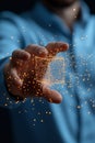 Hand holding glowing holographic cube with sparkling particles around it