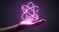 Hand holding glowing neon atom model with orbiting electrons atomic science Royalty Free Stock Photo