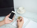 Hand holding gold bitcoin and mobilephone with workspace on white wood table background Royalty Free Stock Photo