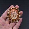 Hand holding a golden brooch with the lady cameo Royalty Free Stock Photo
