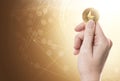 Hand holding a golden Ethereum coin on a bright background with blockchain network. Copy space included.