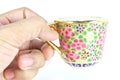 Hand holding a golden thai tea cup Royalty Free Stock Photo