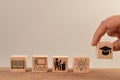 Hand holding graduation cap with bulb, student, classroom and book on wooden blocks. Key to success concept Royalty Free Stock Photo