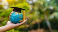 Hand holding graduation cap with earth globe on nature background. Concept of global business study, abroad education Royalty Free Stock Photo