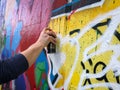 Hand holding graffiti can spraying on wall Royalty Free Stock Photo