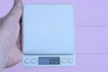 hand holding a gray square electronic scale Royalty Free Stock Photo