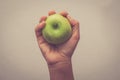 Hand holding green apple with hand with filter effect retro vintage style Royalty Free Stock Photo