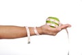 Hand holding green apple with measuring tape. Royalty Free Stock Photo