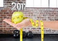 Hand holding green apple wrapped with measuring tape against 3D 2017 Royalty Free Stock Photo