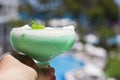 Hand holds green cocktail in a beautiful glass with ice cream an Royalty Free Stock Photo