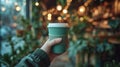 a hand holding a green disposable coffee cup in a cafeteria