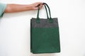 A hand holding a green and gray felt tote bag Royalty Free Stock Photo