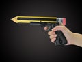 Hand holding gun with pencil point Royalty Free Stock Photo