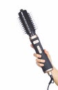 Hand holding hair curling iron round brush