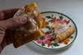 Hand holding half of a broken apple hand-pie turnover above a plate