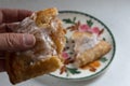 Hand holding half of a broken apple hand-pie turnover above a plate