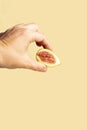 Hand holding a half fig on a beige background Royalty Free Stock Photo