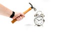 Hand holding a hammer beating an alarm clock