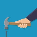 Hand holding hammer and a nail, flat design Royalty Free Stock Photo