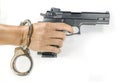 Hand holding a hand gun with handcuffs Royalty Free Stock Photo