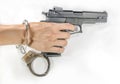 Hand holding a handgun with handcuffs Royalty Free Stock Photo