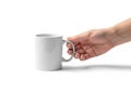 A hand holding the handle of a plain white ceramic mug against a Royalty Free Stock Photo