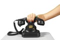Hand holding the handset of an old black vintage rotary-style telephone Royalty Free Stock Photo