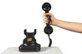 Hand holding the handset of an old black vintage rotary-style telephone Royalty Free Stock Photo