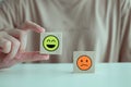 Hand holding happy face from unhappy face on wooden block. Positive thinking, World mental health day concept Royalty Free Stock Photo