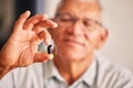 Hand holding hearing aid, senior man and tech for ears, health and wellness for retirement in nursing home. Elderly Royalty Free Stock Photo