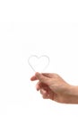 Hand holding a heart mold on a white background. Vertical photo. Symbol for ValentineÃ¢â¬â¢s Day and love