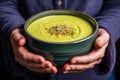 hand holding a hearty, indulgent bowl of broccoli cheddar soup