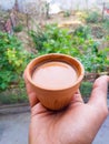 Hand holding Hot Indian spiced tea served in a traditional clay pot glass called Kulhad. Uttarakhand , India Royalty Free Stock Photo