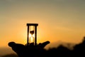 Hand holding Hourglass with sunrise in the morning, Time Concept Royalty Free Stock Photo