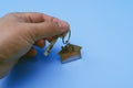 Hand Holding House Key Against Blue Background Royalty Free Stock Photo